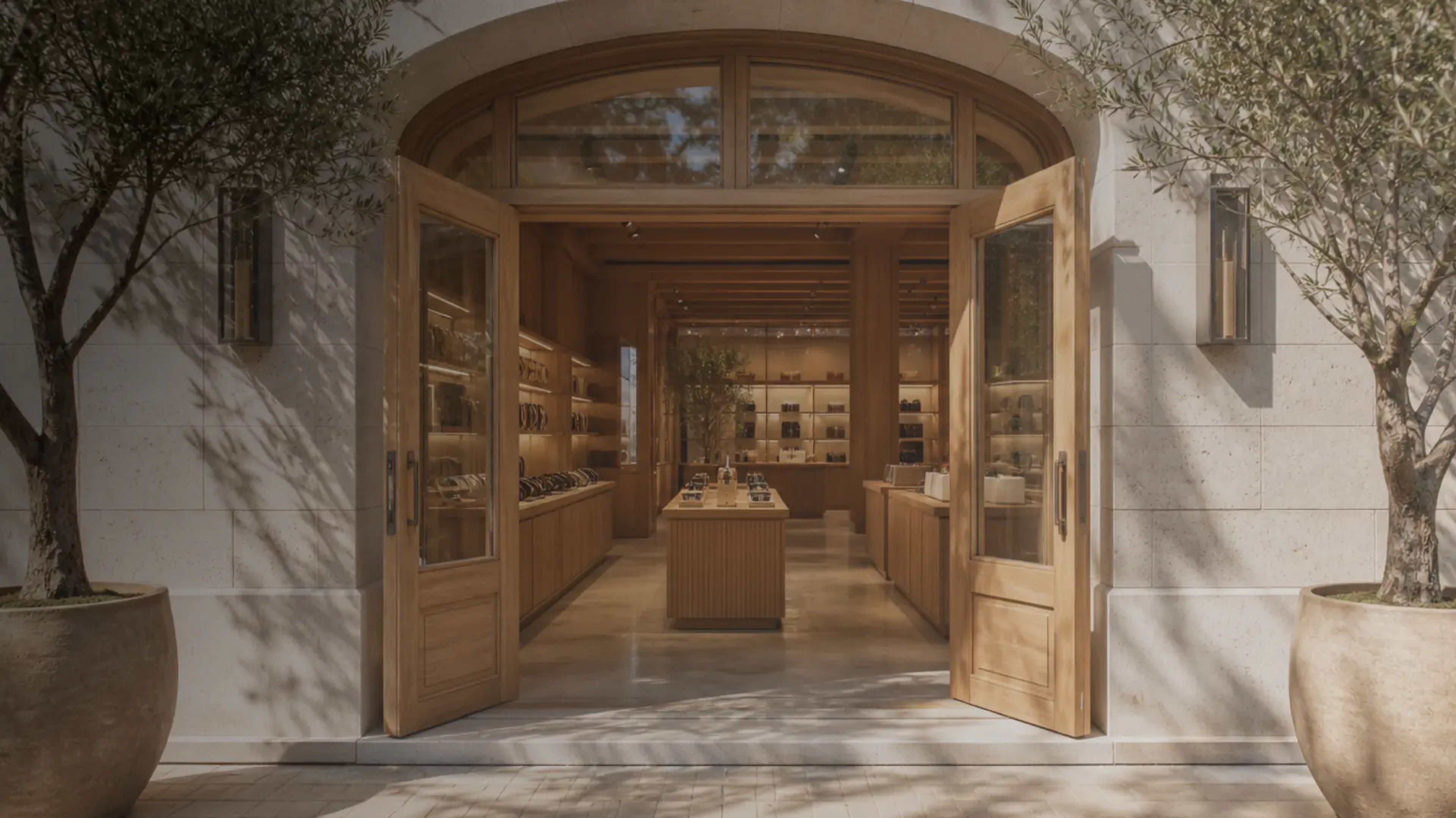 The Elio flagship in Double Bay, Sydney — a stone arch entrance with open oak doors and olive trees in planters